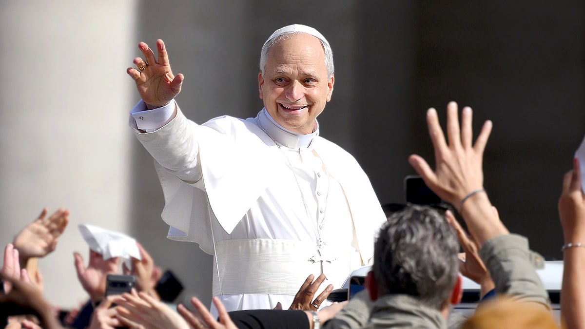 Pope Leo XIV waves to the crowd in St. Peter’s Square as he arrives for his inauguration Mass in Vatican City.