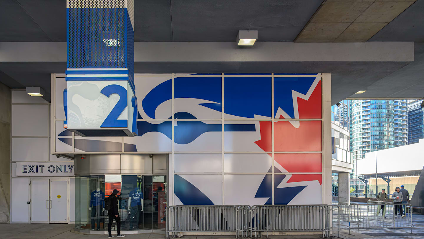 A person walking past a Blue Jays MLB team exhibit inside...
