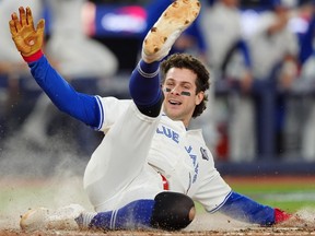 Toronto Blue Jays' Ernie Clement slides into home plate to score on a double by Andrés Giménez during the sixth inning of World Series Game 7.