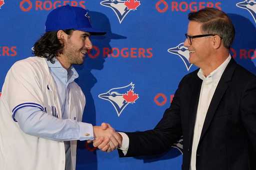 Dylan Cease pitcher for the Toronto Blue Jays shakes hands with Ross Atkins general manager of the Toronto Blue Jays, after he was presented with a team hat and jersey during a news conference at the Major League Baseball