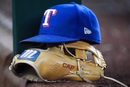 The glove and hat of Texas Rangers third baseman Josh Jung are seen in the dugout during the...