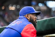 Texas Rangers outfielder Adolis García watches from the dugout during a baseball game...