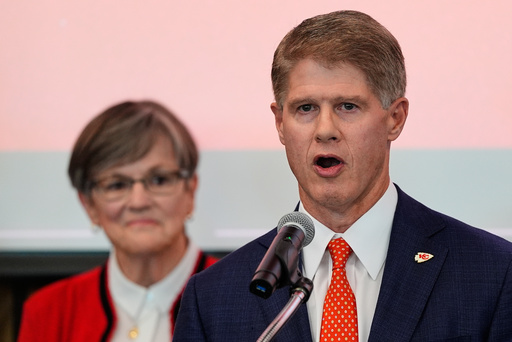 Kansas City Chiefs owner Clark Hunt, right, addresses attendees while Kansas Gov. Laura Kelly, left, looks on during an event Monday, Dec. 22, 2025, in Topeka, Kan., announcing the team will leave Arrowhead Stadium in Kansas City, Mo. for a new stadium that will be built across the Kansas-Missouri state line and be ready for the start of the 2031 season. (AP Photo/Charlie Riedel)