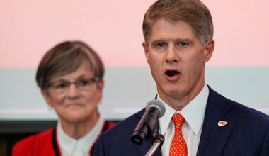 Kansas City Chiefs owner Clark Hunt, right, addresses attendees while Kansas Gov. Laura Kelly, left, looks on during an event Monday, Dec. 22, 2025, in Topeka, Kan., announcing the team will leave Arrowhead Stadium in Kansas City, Mo. for a new stadium that will be built across the Kansas-Missouri state line and be ready for the start of the 2031 season. (AP Photo/Charlie Riedel)