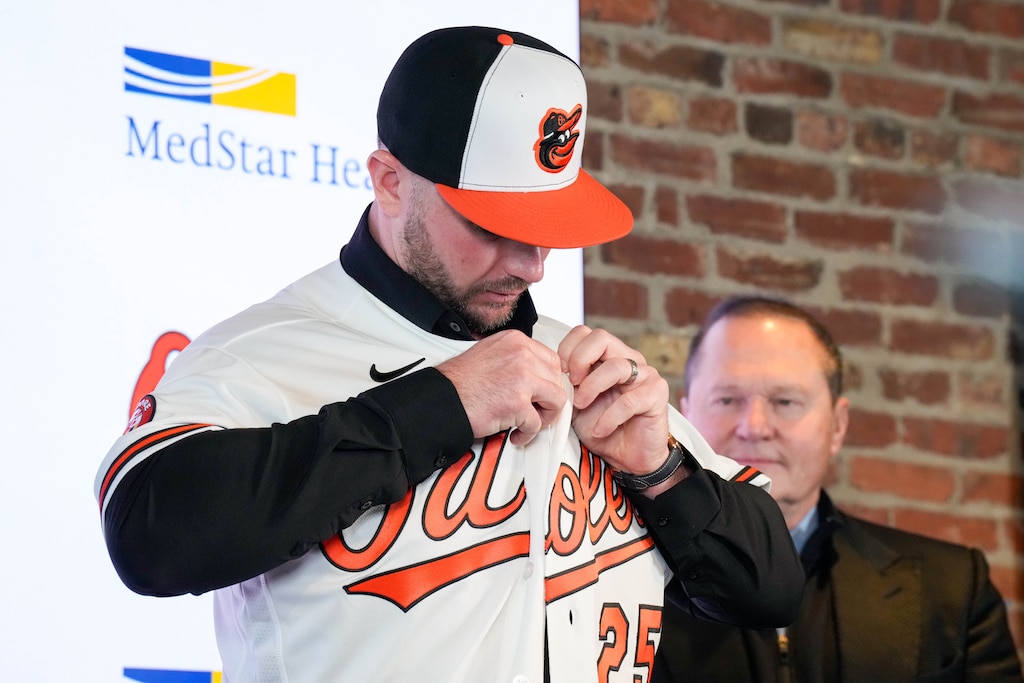 Newly signed Orioles first baseman Pete Alonso puts on his new team’s jersey as he’s introduced during a press conference at Oriole Park at Camden Yards in Baltimore, Md. on Friday, December 12, 2025.