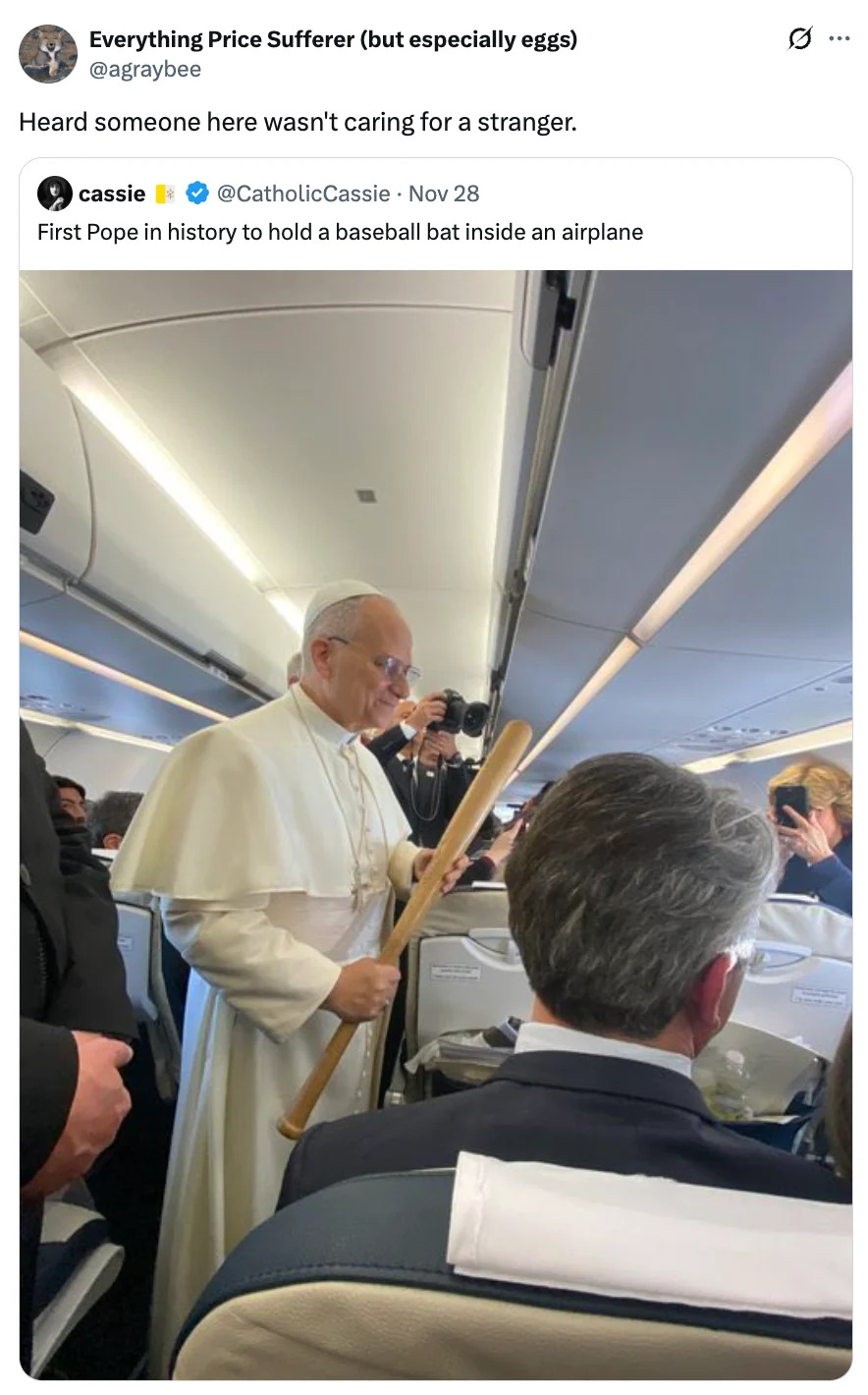 A person in papal attire holds a baseball bat inside an airplane, interacting with seated passengers. 