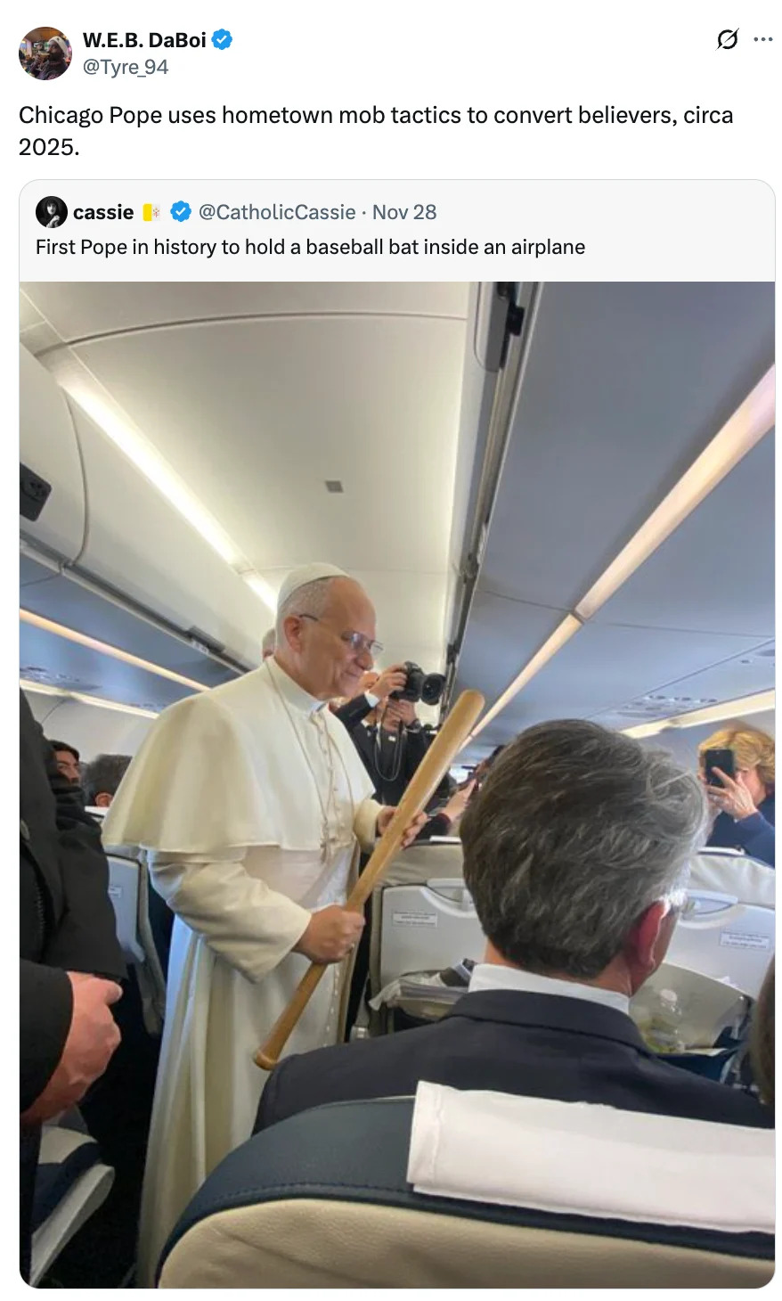 Pope in traditional attire holds a baseball bat while standing in an airplane aisle, interacting with passengers