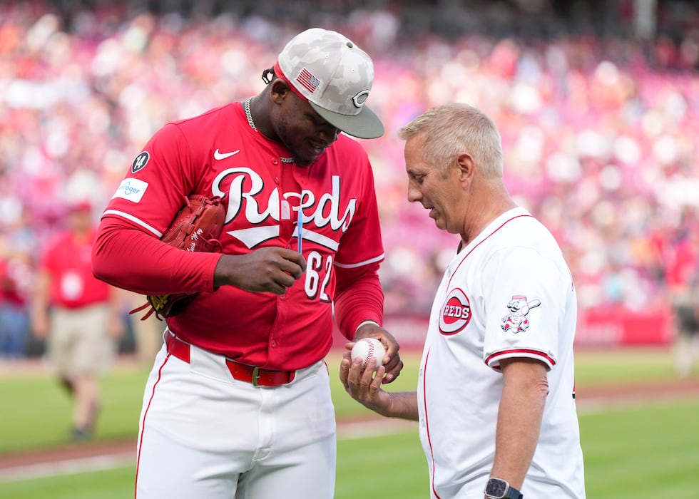 Cincinnati Reds pitcher Luis Mey (62) autographs a ball with NASCAR driver Greg Biffle prior...