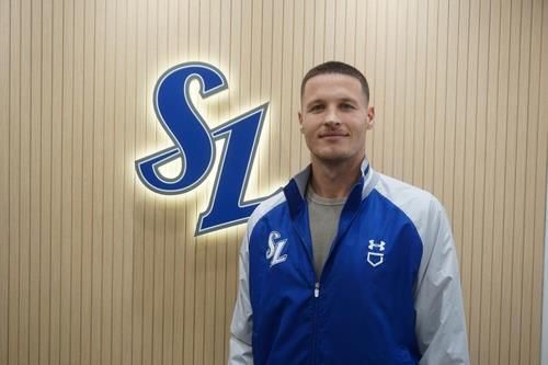 New Samsung Lions pitcher Matt Manning poses in front of the team's logo at Daegu Samsung Lions Park in the southeastern city of Daegu, Monday, in this photo provided by the Lions. Yonhap