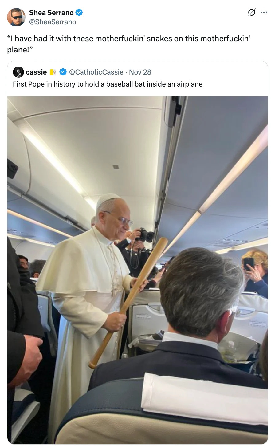 A person dressed as a pope humorously holds a baseball bat on a plane, referencing the film "Snakes on a Plane."