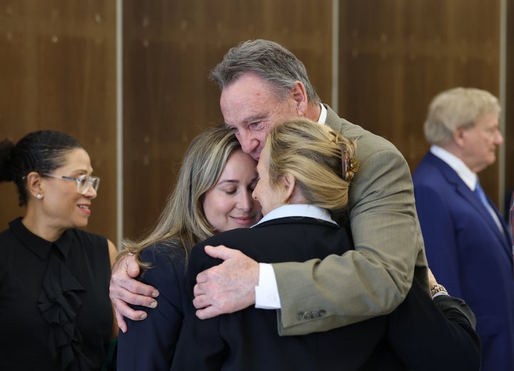 Carli Skaggs, left center, and her mother, Nina Miles, are embraced by attorney William Haggerty after a settlement was reached in the wrongful death lawsuit by the family of pitcher Tyler Skaggs against the Los Angeles Angels at Orange County Superior Court in Santa Ana on Friday, Dec. 19, 2025. (Allen J. Schaben / Los Angeles Times via Getty Images)
