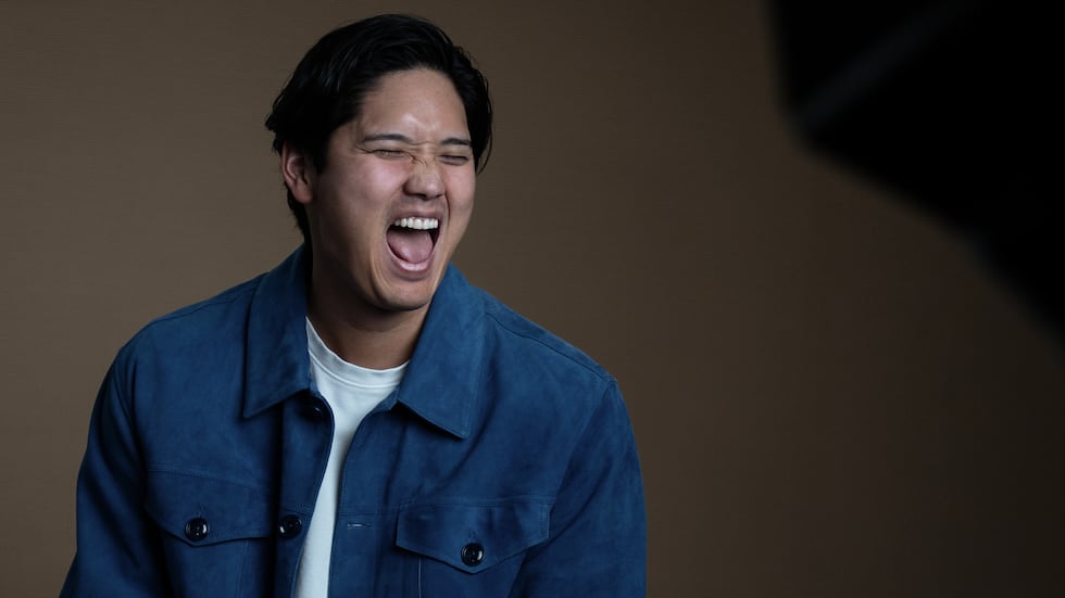 Los Angeles Dodgers' Shohei Ohtani shares a laugh with his translator during an interview with...
