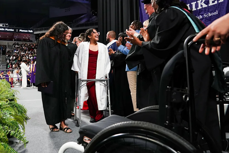 Gissel Mendoza Urdaneta, 17, is walked across the stage during a graduation ceremony for Aiken High School, Wednesday, May 21, 2025, at Fifth Third Arena in Cincinnati.