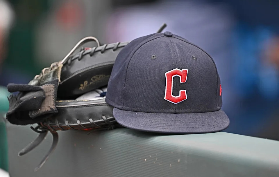 Jun 27, 2024; Kansas City, Missouri, USA; A general view a Cleveland Guardians hat and glove on the dugout railing before a game against the Kansas City Royals at Kauffman Stadium. Mandatory Credit: Peter Aiken-Imagn Images