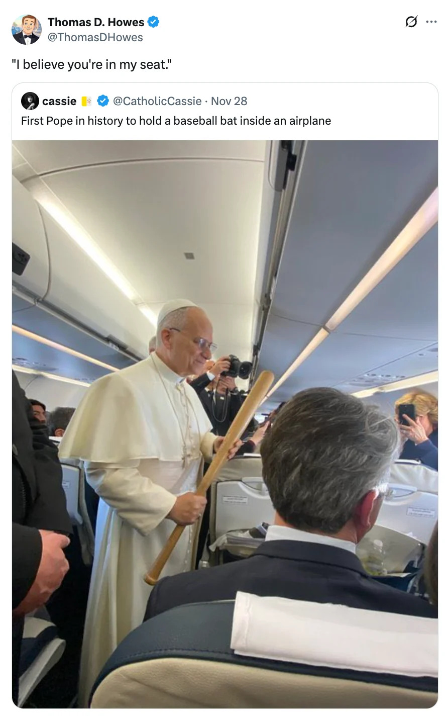 Person resembling a religious figure holds a large bat inside an airplane, causing amusement among passengers