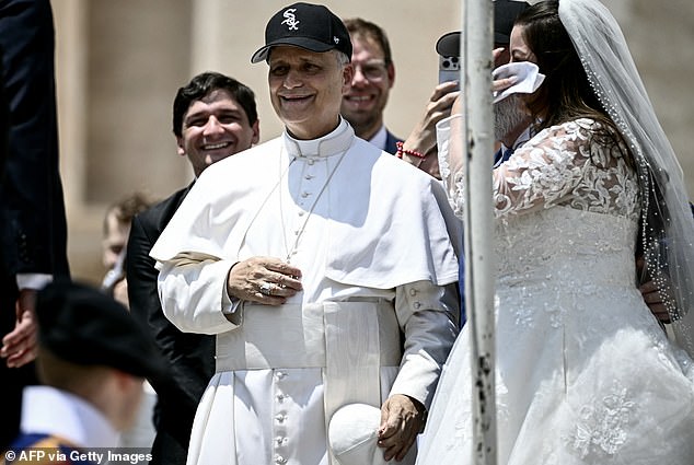 Pope Leo throws on a White Sox hat over his zucchetto while blessing a couple in June