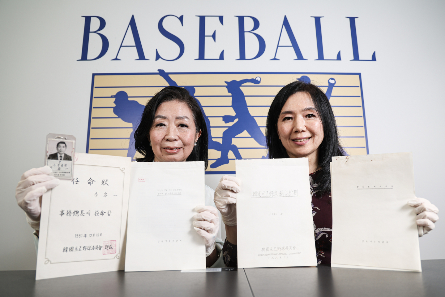 Lee Geum-hee, left, and Lee Ji-hyun, the daughters of the KBO’s first secretary general Lee Yong-il, hold their father’s memorabilia at the KBO on Dec. 2. [KIM KYOUNG-ROK]