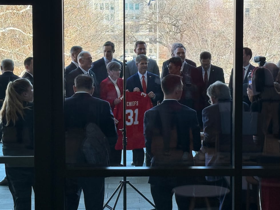 The Hunt family and Governor Laura Kelly present a Chiefs jersey following the approval of...