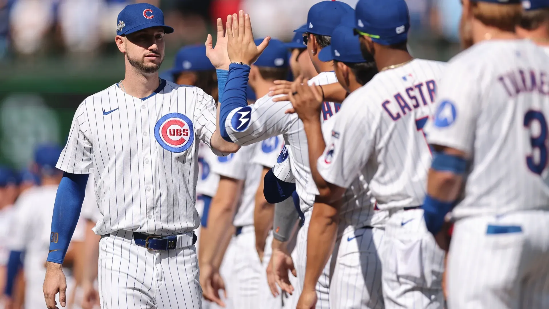 Kyle Tucker #30 with the Cubs high fives teammates during pregame. Michael Reaves/Getty Images