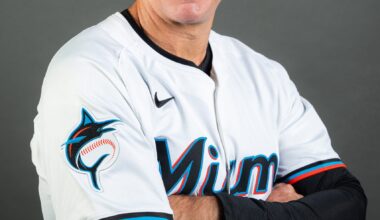 Clayton McCullough, smiling and wearing a Miami Marlins uniform and cap, poses with arms crossed in front of a gray studio backdrop.