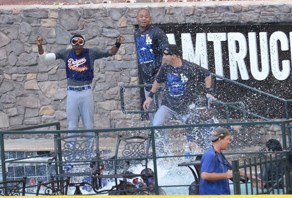Los Angeles Dodgers players jump in the pool after clinching the National League West after a 7-6 win against the Arizona Diamondbacks 