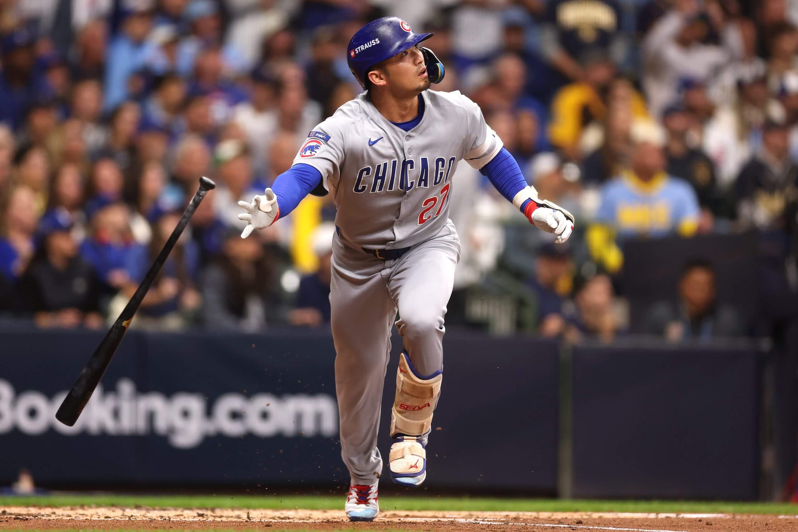 Seiya Suzuki of the Chicago Cubs drops his bat and watches a hit ball fly as he begins to run toward first base.