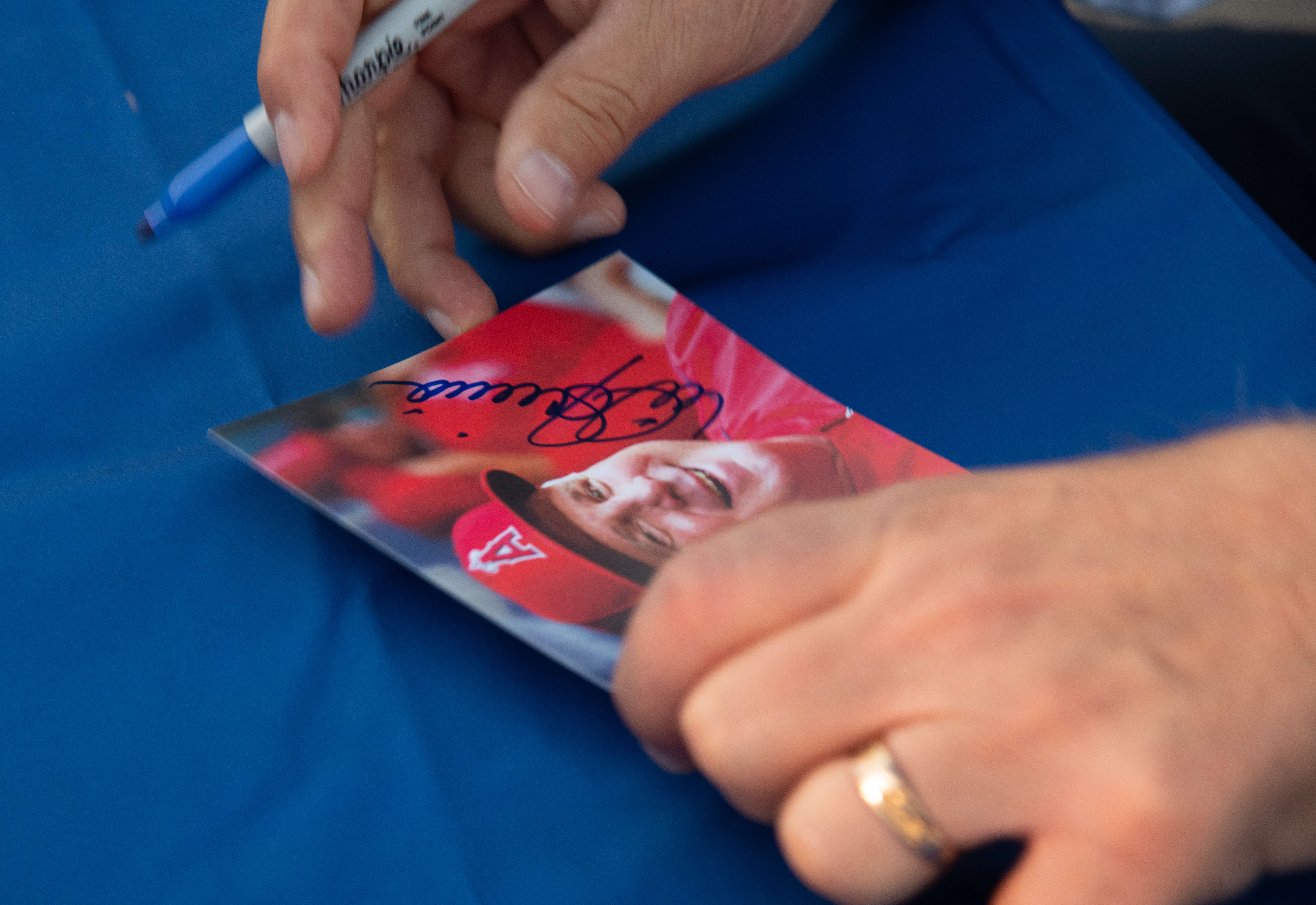 Former Los Angeles Angels manager Mike Scioscia signs autographs Saturday,...