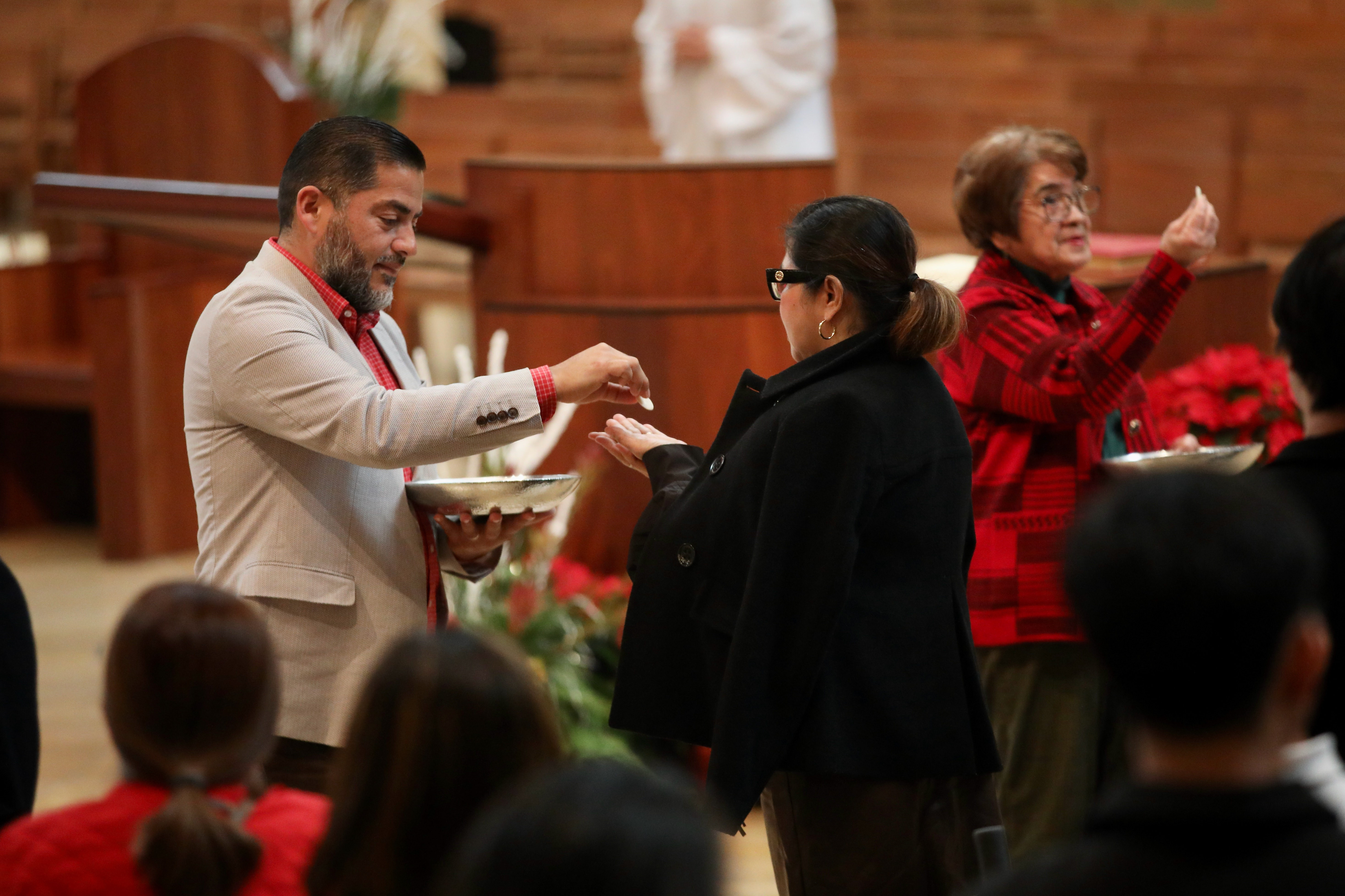 Parishioners receive Communion at a Christmas Day Mass at the...