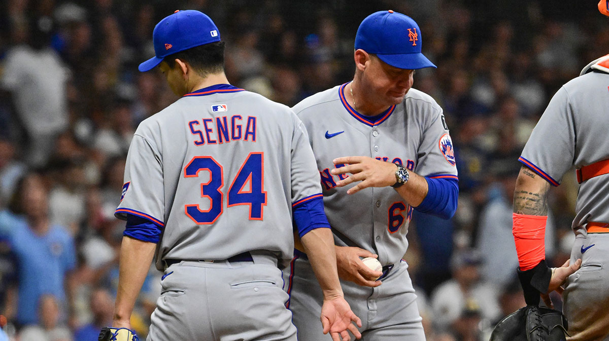 New York Mets manager Carlos Mendoza takes the ball from starting pitcher Kodai Senga (34) during a pitching change in the fifth inning against the Milwaukee Brewers at American Family Field.