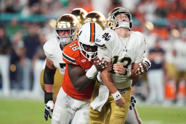 Miami defensive lineman Armondo Blount (18) pressures Notre Dame quarterback CJ Carr (13) during the second half of an NCAA college football game, Sunday, Aug. 31, 2025, in Miami Gardens, Fla. (AP Photo/Lynne Sladky)