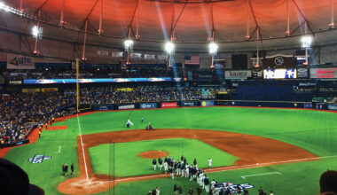 The inside of Tropicana Field, home of the baseball team the Tampa Bay Rays. Lit with orange ceiling and green grass after a game