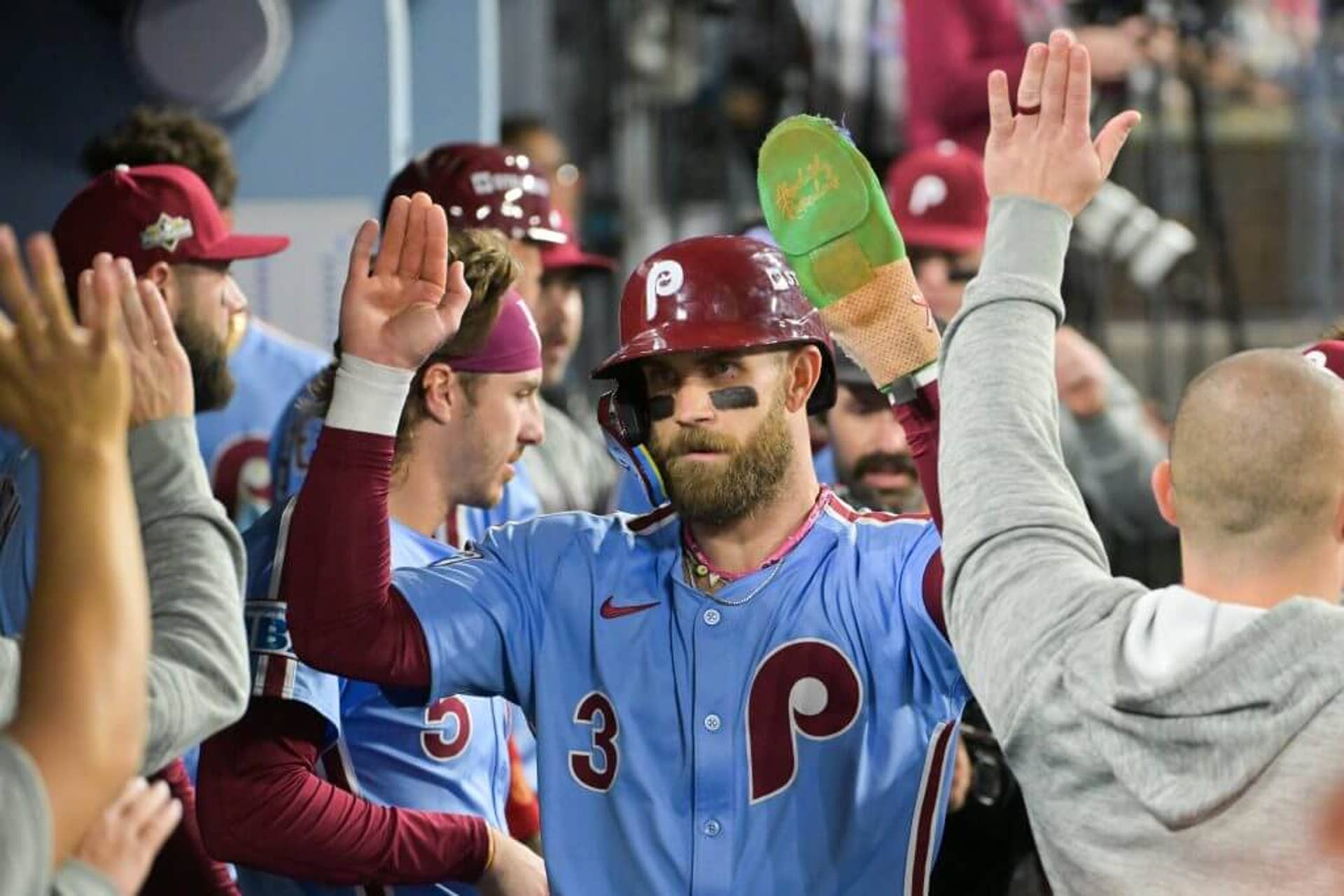 Phillies first baseman Bryce Harper high fives teammates in the dugout after scoring against the Dodgers.