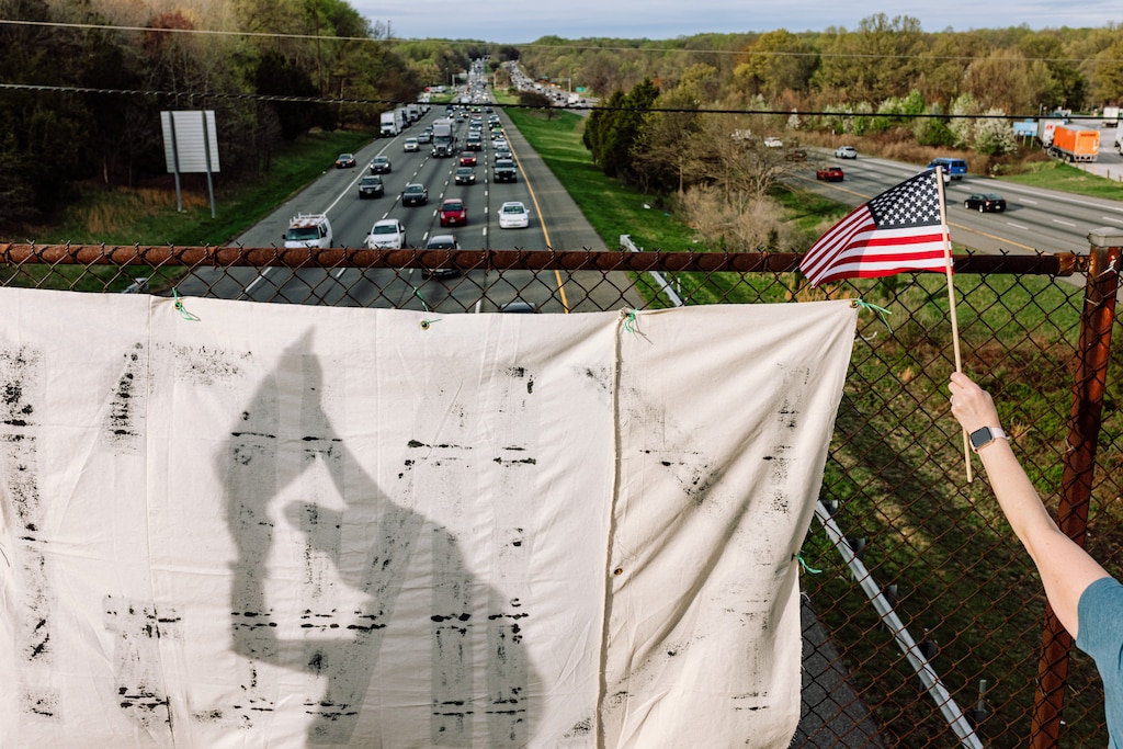 Demonstrators hold signs during a weekly sign-waving protest in opposition to President Donald Trump, billionaire Elon Musk and the DOGE federal workforce cuts on the Gorman Road I-95 overpass in Laurel, MD on Friday, April 4, 2025.