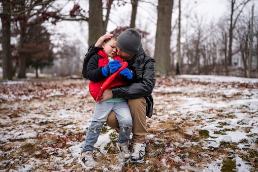 Derek Smith holds his son Jaxon Smith in the front yard of his mother’s home, in Elkton, Saturday, December 6, 2025.