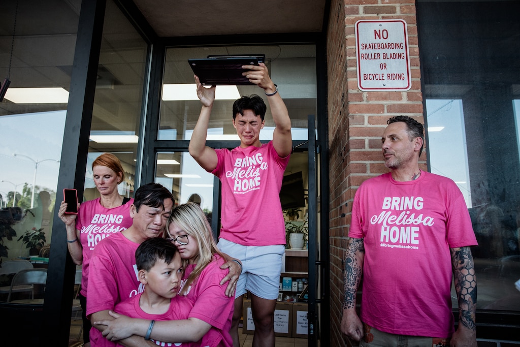 Jackson Hoang, 19, holds up a laptop to a crowd showing his mother, Mong “Melissa” Tuyen Thi Tran, on a video call from an ICE detention center. The local community organized a fundraising and action meeting to help bring Melissa back.