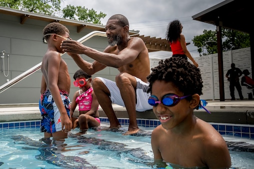Richard Brooks, 55, adjusts goggles for Kairay Jones, 7, at  the Towanda Rec Center Pool on July 16, 2025.