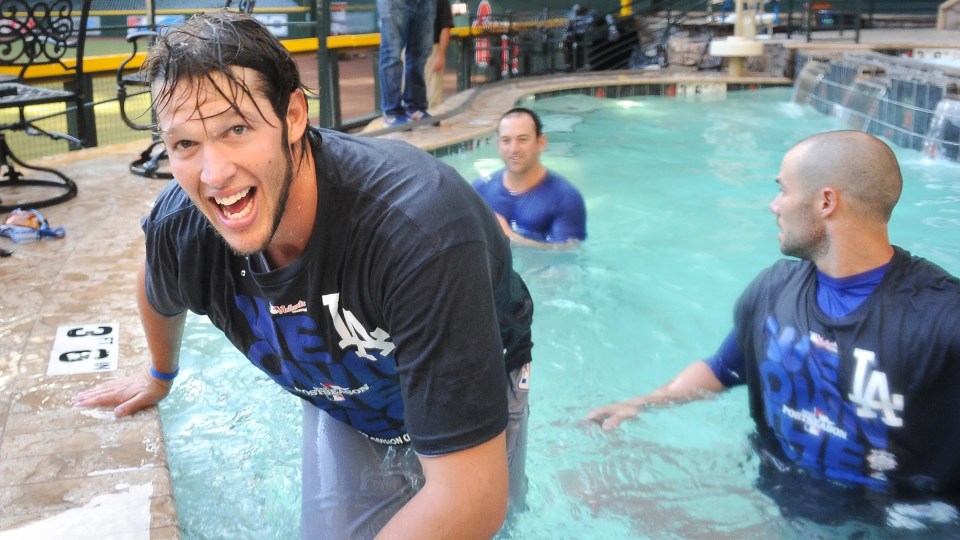 Dodgers pitcher Clayton Kershaw celebrates in the pool with his teamates after defeating the Diamondbacks and clinching a playoff spot at Chase Field