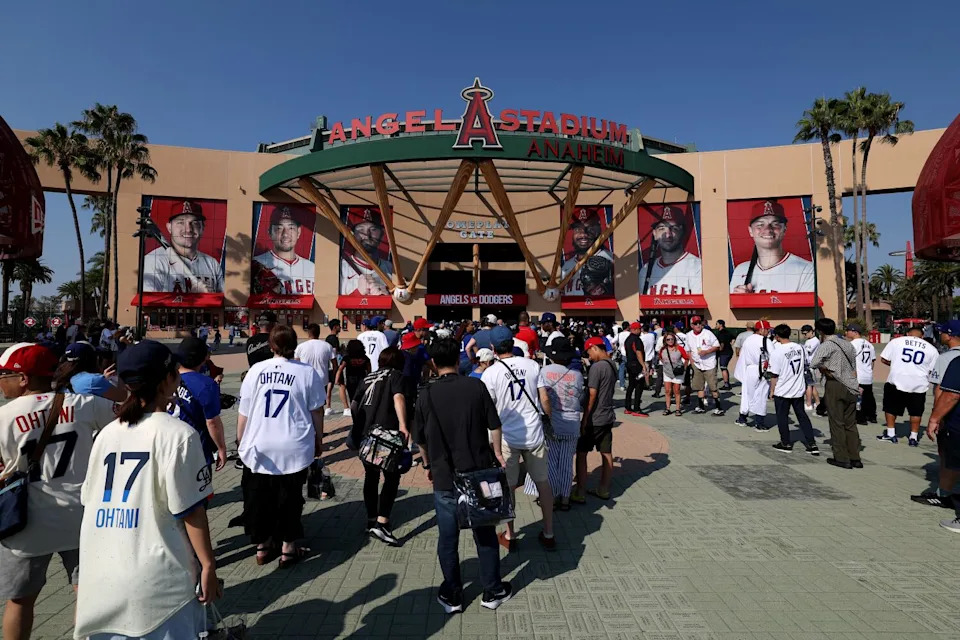 Fans wearing Shohei Ohtani Dodgers jerseys wait to enter Angel Stadium before a game between the Angels and Dodgers.