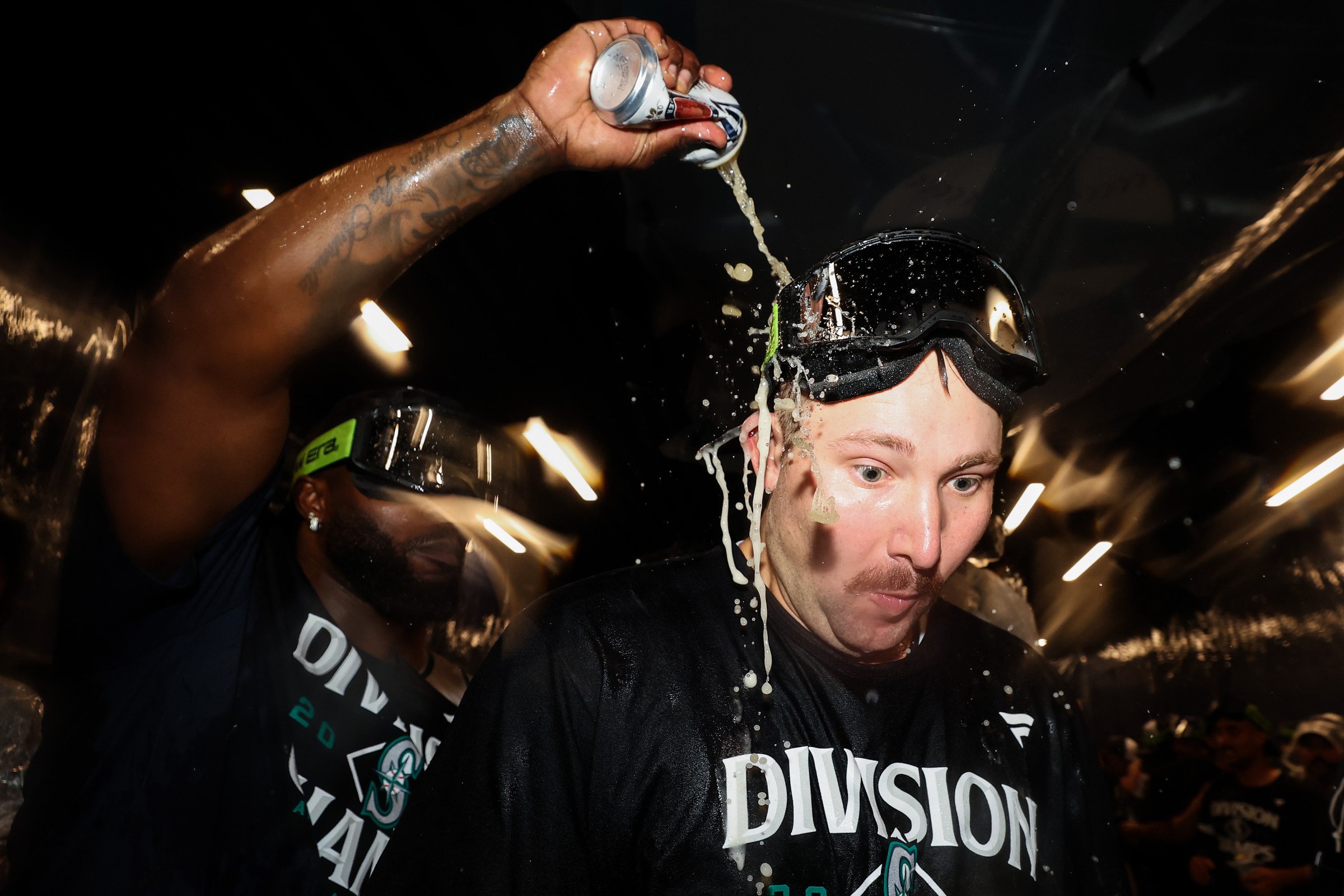 SEATTLE, WASHINGTON - SEPTEMBER 24: Randy Arozarena #56 douses Cal Raleigh #29 of the Seattle Mariners after winning the American League West after the game against the Colorado Rockies at T-Mobile Park on September 24, 2025 in Seattle, Washington. (Photo by Steph Chambers/Getty Images)