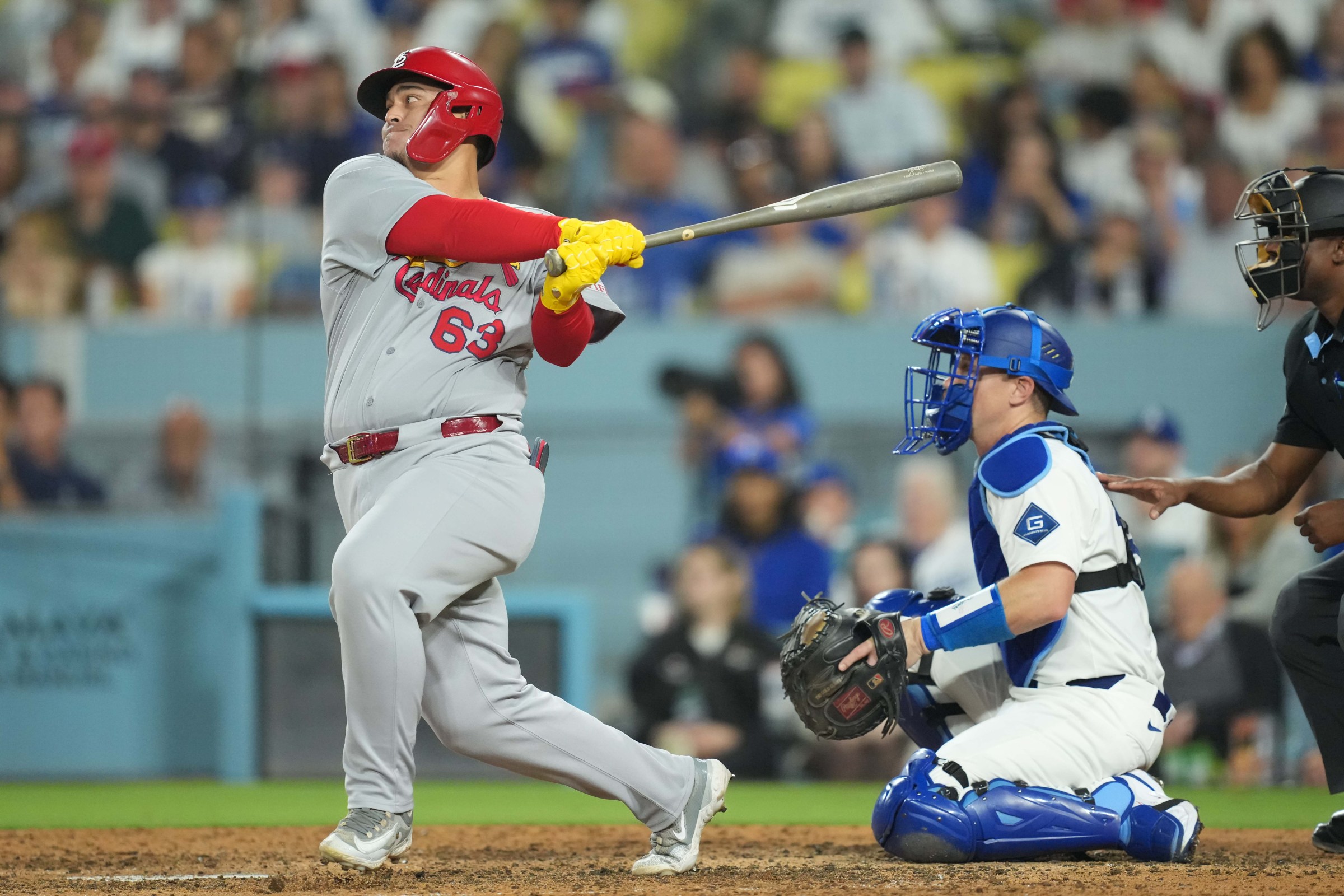 Aug 4, 2025; Los Angeles, California, USA; St. Louis Cardinals catcher Yohel Pozo (63) singles to right field and scores second base Garrett Hampson (13) in the top of the ninth inning at Dodger Stadium. Mandatory Credit: Kirby Lee-Imagn Images