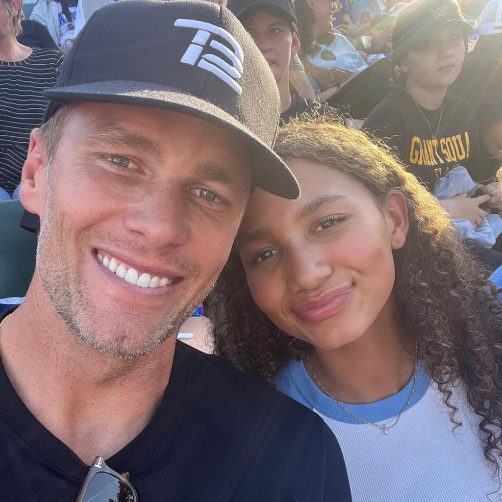 Tom Brady and Maya Brady smiling for a selfie at a sporting event.
