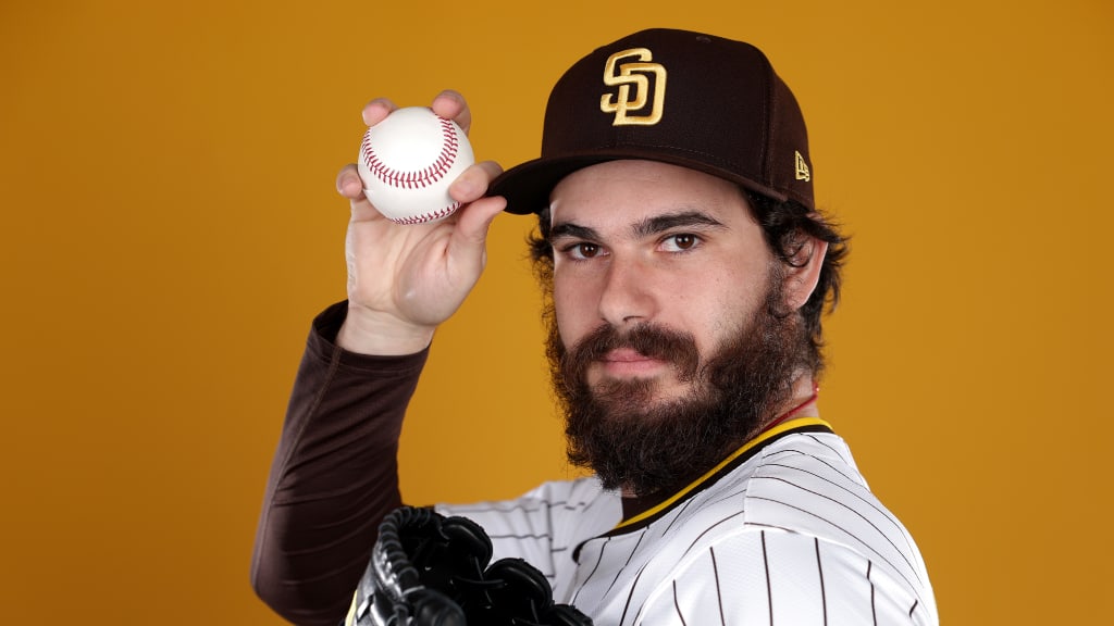 Dylan Cease standing confidently while holding a baseball in his right hand, posing in a relaxed stance with a focused expression, showcasing his role as a star MLB pitcher.