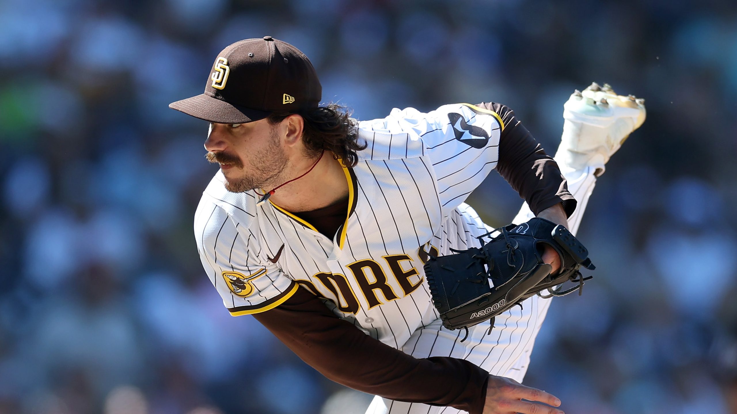 Dylan Cease delivering a pitch in full motion while wearing the San Diego Padres uniform, showcasing his intense focus and athletic form on the mound.