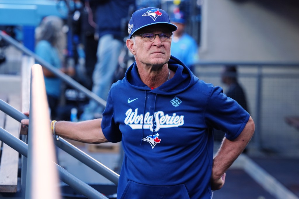 Toronto Blue Jays bench coach Don Mattingly stands and watches from the dugout during the World Series.