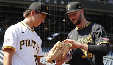 Jul 22, 2025; Pittsburgh, Pennsylvania, USA;  Seth Hernandez (left) the Pittsburgh Pirates first round and number six overall pick in the 2025 first year player draft looks at the glove of Pirates pitcher Paul Skenes (30) before the game against the Detroit Tigers at PNC Park. Mandatory Credit: Charles LeClaire-Imagn Images