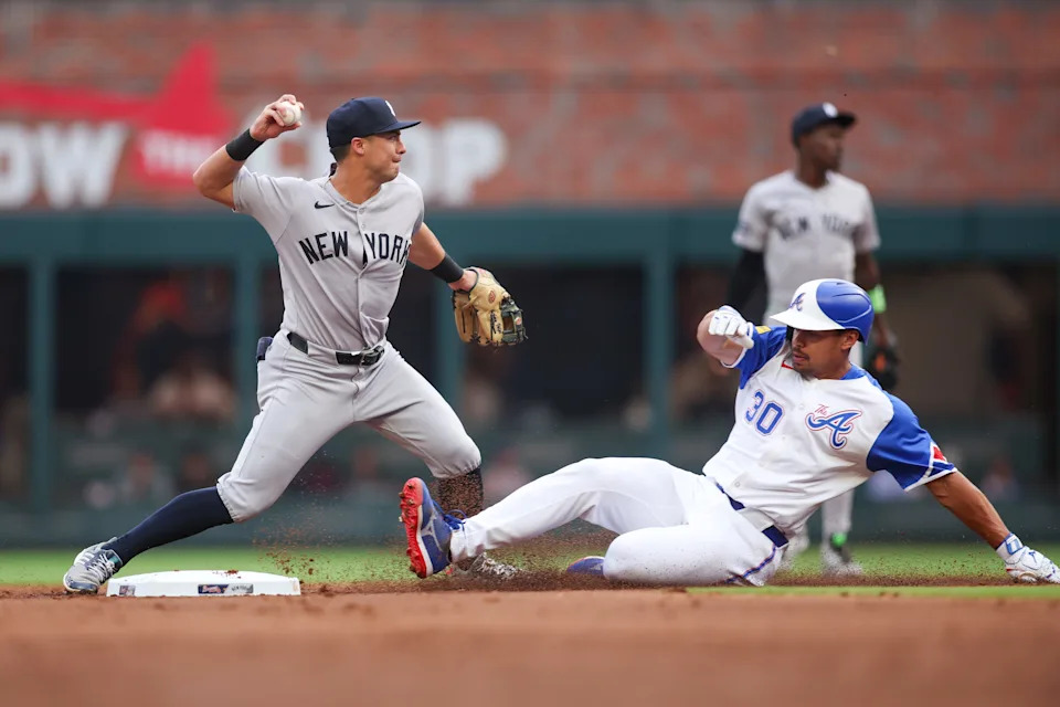 Jul 19, 2025; Atlanta, Georgia, USA; New York Yankees shortstop Anthony Volpe (11) turns a double play over Atlanta Braves catcher Drake Baldwin (30) in the second inning at Truist Park. Mandatory Credit: Brett Davis-Imagn Images