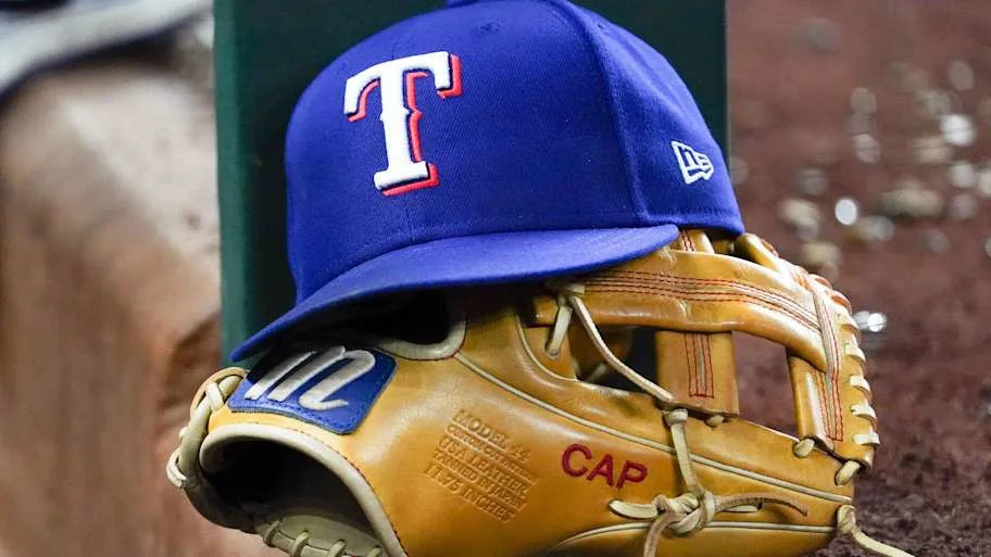A Texas Rangers cap and baseball mitt sit on the dugout steps.