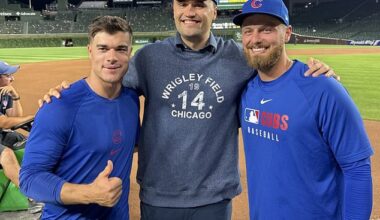 Charlie Kirk (center) is flanked by Cubs infielders Matt Shaw (left) and Michael Busch (right)