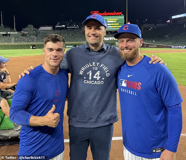 Charlie Kirk (center) is flanked by Cubs infielders Matt Shaw (left) and Michael Busch (right)