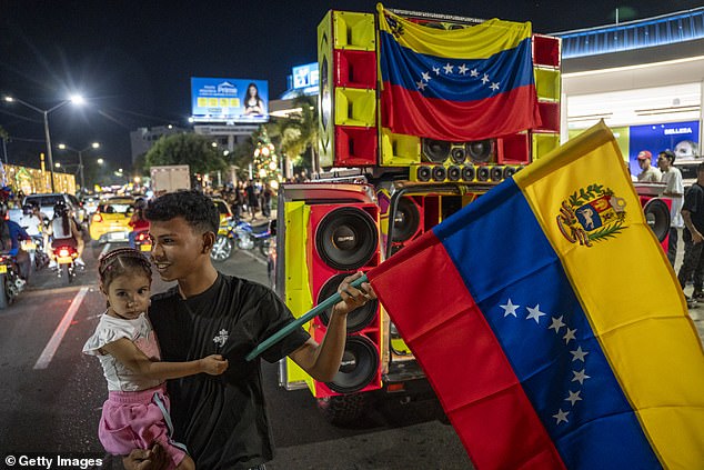 A child waves a Venezuelan flag on the Colombia-Venezuela border during a rally after the confirmation of Nicolas Maduro's capture this early morning in Caracas, on Saturday